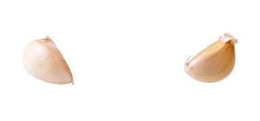 İki soyulmamış sarımsak karanfilinden oluşan üst görünüm kümesi kırpma yolu ile beyaz zemin üzerinde izole edilmiştir.