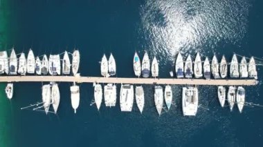 Yat marinası körfezin güzelliğinin yavaş görüntüsü demirli yatları ve kristal berrak turkuaz suları olan bir iskelenin sükuneti. Yüksek kalite 4k görüntü