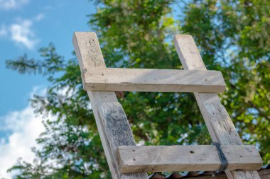  Arka planda mavi gökyüzü olan eski ahşap bir merdiven. Zirveye ulaşmak için. Yüksek kalite fotoğraf