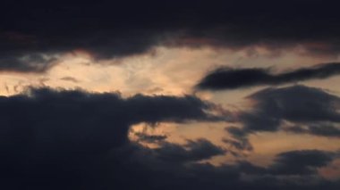 Gün batımını yakalayan bir zaman çizelgesi. Güneş ışınları karanlık ve dalgalı bulutların ardında kaybolurken dramatik bir olay yaratıyor. Yüksek kaliteli FullHD görüntüler