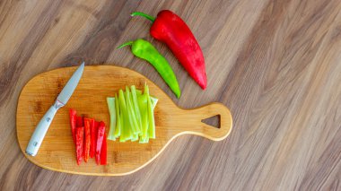 Bir bıçağın yüksek açılı görüntüsü ve ahşap kesim tahtası, kırsal ahşap bir masada çeşitli taze sebzeler. Metin için boş alan. Yüksek kalite fotoğraf