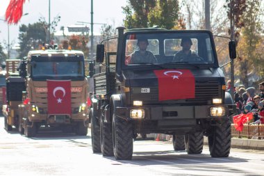 Cumhuriyet Günü kutlamaları sırasında Türk bayrağıyla süslenmiş askeri kamyon geçidi ulusal gurur ve gücü simgeliyor. 10.29.2023 - Erzurum, Türkiye.