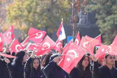 Öğrenciler, Cumhuriyet Günü kutlamalarında vatanseverlik yürüyüşünde Türk bayraklarını sallayarak genç neslin ruhunu ve birliğini simgeliyor. 29 Ekim 2023 - Erzurum, Türkiye .