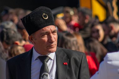 Atatürk 'e benzeyen bir adam, Türk tarihinin bir simgesi olan geleneksel bir fes takarak 29 Ekim kutlamaları sırasında kalabalığa karışıyor. 29 Ekim 2023 - Erzurum, Türkiye .