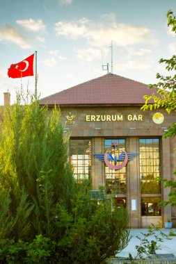 Erzurum 'daki ana tren istasyonu manzarası veya Erzurum Tren Gari. Erzurum, Türkiye 'de daha popüler bir turizm beldesi. El sallayan Türk bayrağıyla. Erzurum Türkiye - 25 Temmuz 2024.