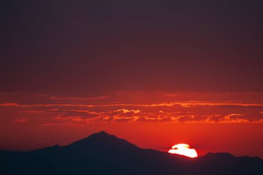 Dağların üzerinde canlı günbatımı, metin alanı ile arkaplan için ideal, sonları ve yeni başlangıçları sembolize ediyor.