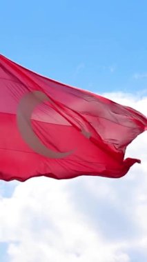 Türk bayrağının açık mavi gökyüzüne karşı dalgalanan yakın çekimi, metin alanı ile dikey arkaplanlar için ideal, ulusal gurur ve özgürlüğü simgeliyor.