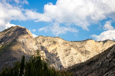 Tortum, Erzurum, Türkiye 'de güç ve huzuru sembolize eden canlı mavi gökyüzünün altındaki görkemli dağ zirveleri