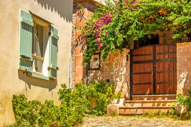 Edremit, Balikesir 'de yaz atmosferini çağrıştıran hareketli çiçekler ve büyüleyici bir pencerenin bulunduğu sakin bir avlu. Seyahat ve tatil tasarımları için mükemmel.. 