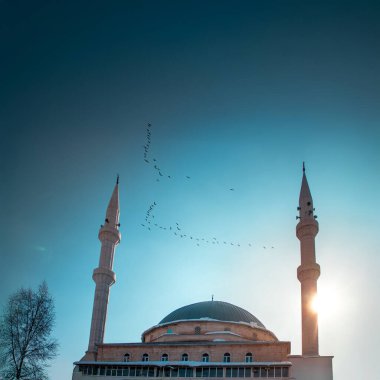 Ramadan or Islamic nights background. Peaceful mosque silhouette with flying birds of Haci Osman Efendi Mosque in Erzurum clipart