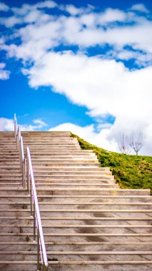 Mavi gökyüzüne yükselen bir merdiven tutku, büyüme ve gelecekteki hedefleri sembolize eder. Başarı, umut ve amaç için görsel bir metafor..