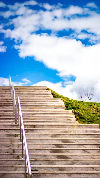Mavi gökyüzüne yükselen bir merdiven tutku, büyüme ve gelecekteki hedefleri sembolize eder. Başarı, umut ve amaç için görsel bir metafor..