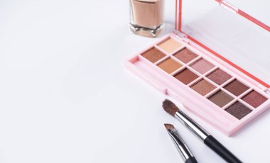 Beige eye shadow palette with brush on white background. Decorative cosmetics. Beauty products. Nude brown eye shadow.