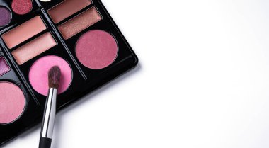 Multi colored eye shadow palette with brush top view. Abstract beauty background with eye shadows and blusher. 