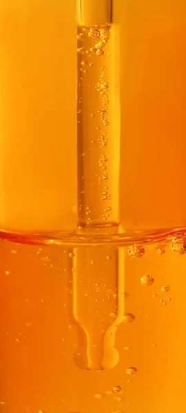 Vitamin C gel serum texture. Liquid gel or serum drop with pipette in orange color.