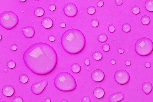 水滴在粉红色的背景色上 补液润肤液滴剂或透明质血清 — 图库照片