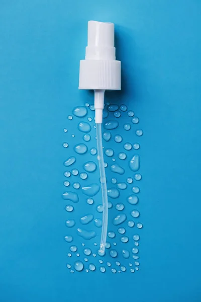 Drops of face serum top view. Liquid gel moisturizer. Creative idea of face serum with pipette on blue background.