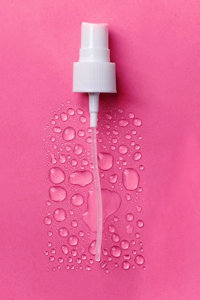 Drops of face serum top view. Liquid gel moisturizer. Creative idea of face serum on pink background.