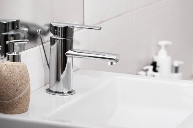 Modern beyaz banyoda lavabo ve musluk. Banyo içinde krom musluk..