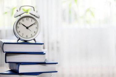 Kopya alanı olan saatli kitap yığını. İş ve eğitim tasarımı için kitap arkaplanı, okul konseptine dönüş.