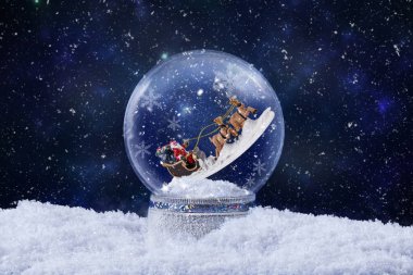 Noel Baba 'nın içinde ren geyiğine bindiği kar küresi. İçinde kar yağan sihirli kar küresi süslemesi olan Noel tebrik kartı. Noel arkaplanı.