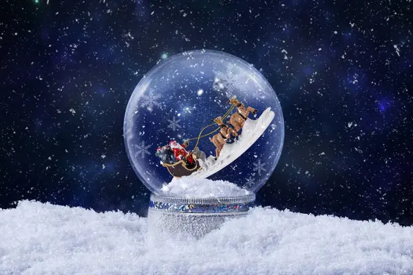 Christmas snow globe with Santa Claus ride on reindeer inside. Christmas greeting card with magic snow globe decoration with snow falling. Christmas background.