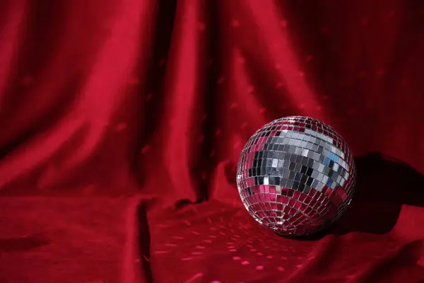 New Year disco ball party background. Christmas backdrop. Shiny gold disco ball over red background.