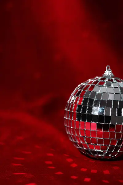 New Year disco ball party background. Christmas backdrop. Shiny gold disco ball over red background.
