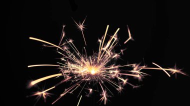 Siyah arka planda yanan maytap ışığı. Yeni yıl partisi geçmişi. Yeni yıl ışıltılarının örtüsü.