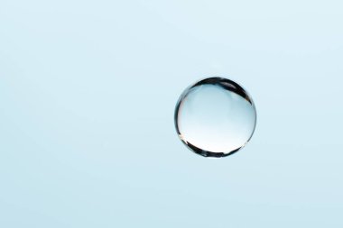 Mavi arkaplanda kopyalama alanı olan kolajen damlası. Tasarım için soyut mavi sıvı damlası. Hyaluronik asit jeli örneği, yaşlanmayı önleyici, nemlendirici cilt bakımı.