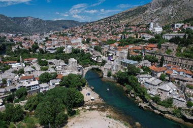 Fantastic Skyline of Mostar with the Mostar Bridge, houses and minarets, during sunny day. Mostar, Old Town, Bosnia and Herzegovina, Europe clipart