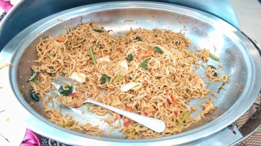 Kızarmış erişte ve sebze büfede servis edilir.