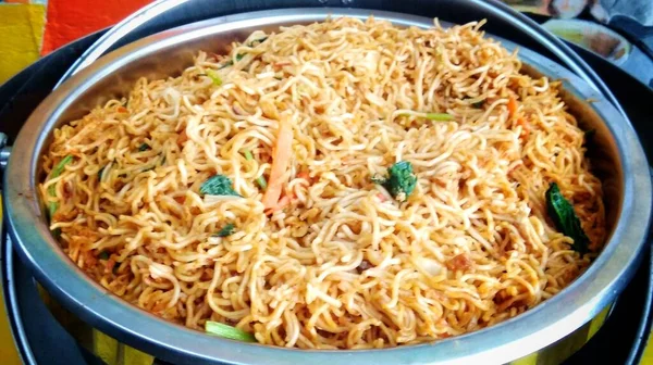 Fried noodles with vegetables are served in a buffet bowl