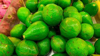 Taze yeşil avokadoların yüksek açılı görüntüsü meyve pazarında sergileniyor