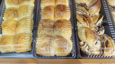 Bir pastanede sergilenen plastik bir kutuda çeşitli aromalı tatlı ekmek.