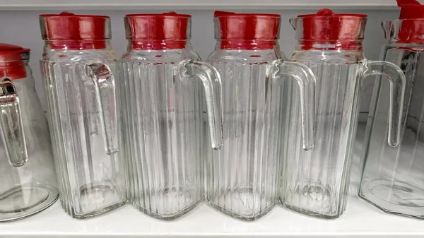 Ev geliştirme mağazasında kırmızı kapaklı bir sürahi su.