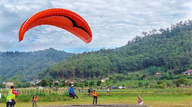 Paraglider pilotu 8 Temmuz 2023 tarihinde Batu City, Doğu Java, Endonezya 'ya indi.