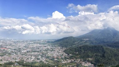 Güzel köy manzarası dağların eteklerinde ve tepelerde mavi gökyüzü ve beyaz bulutlar