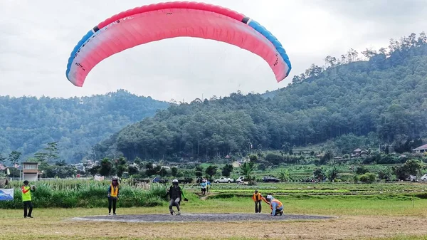 stock image Paraglider pilot landing on field in Batu City, East Java, Indonesia on July 8, 2023