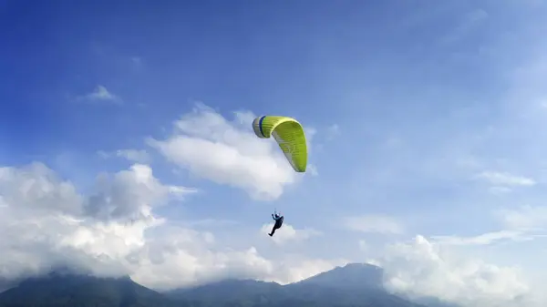 青い空と山の景色の中を飛ぶパラグライダー — ストック写真