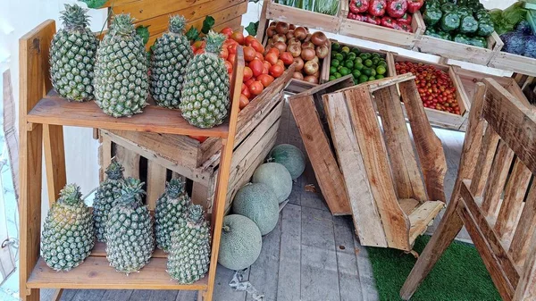 市场上的菠萝和其他蔬菜放在木箱里 — 图库照片