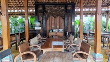 Eski bir Cava tarzı oturma odasında ahşap sandalyeler ve masa