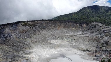 Kireçtaşı kraterlerin, dağların ve tepelerin mavi gökyüzünün ve beyaz bulutların manzarası.