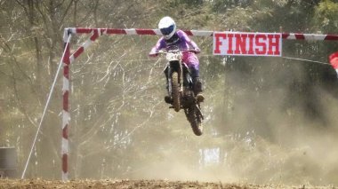 Batu City, Doğu Java, Endonezya - 31 Ağustos 2024: Motokros sürücüleri tozlu toprak yolda atlama cazibesi