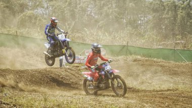 Batu City, Doğu Java, Endonezya - 31 Ağustos 2024: Motokros sürücüleri tozlu toprak yolda yarışıyor