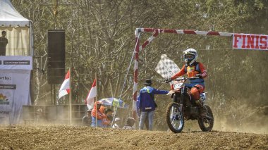 Batu City, Doğu Java, Endonezya - 31 Ağustos 2024: Motokros sürücüleri tozlu toprak yolda yarışıyor