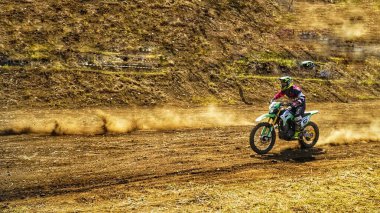 Batu City, Doğu Java, Endonezya - 31 Ağustos 2024: Motokros sürücüleri tozlu toprak yolda yarışıyor