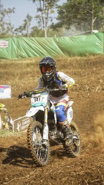 Batu City, Doğu Java, Endonezya - 31 Ağustos 2024: Motokros sürücüleri tozlu toprak yolda yarışıyor