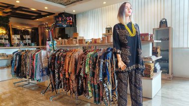Various batik clothes on hangers in the Indonesian traditional cloth market