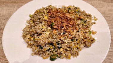 Kızarmış soğanlı leziz pilav beyaz tabakta servis edilir.